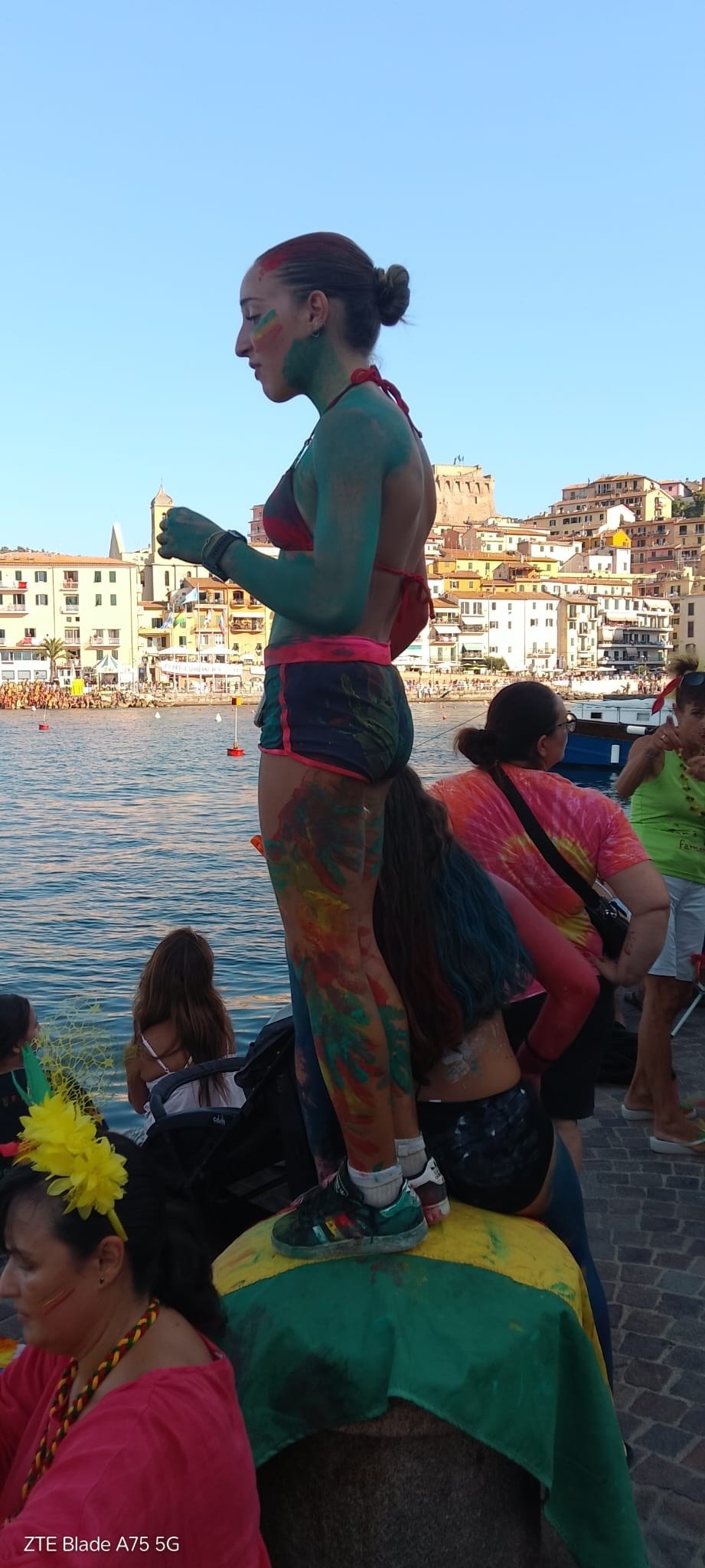 Participante do cortejo do Palio Marinaro diante do porto de Porto Santo Stefano.