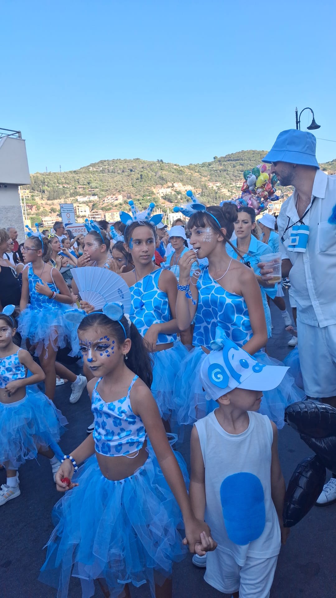 Grupo azul do cortejo com crianças em Porto Santo Stefano.