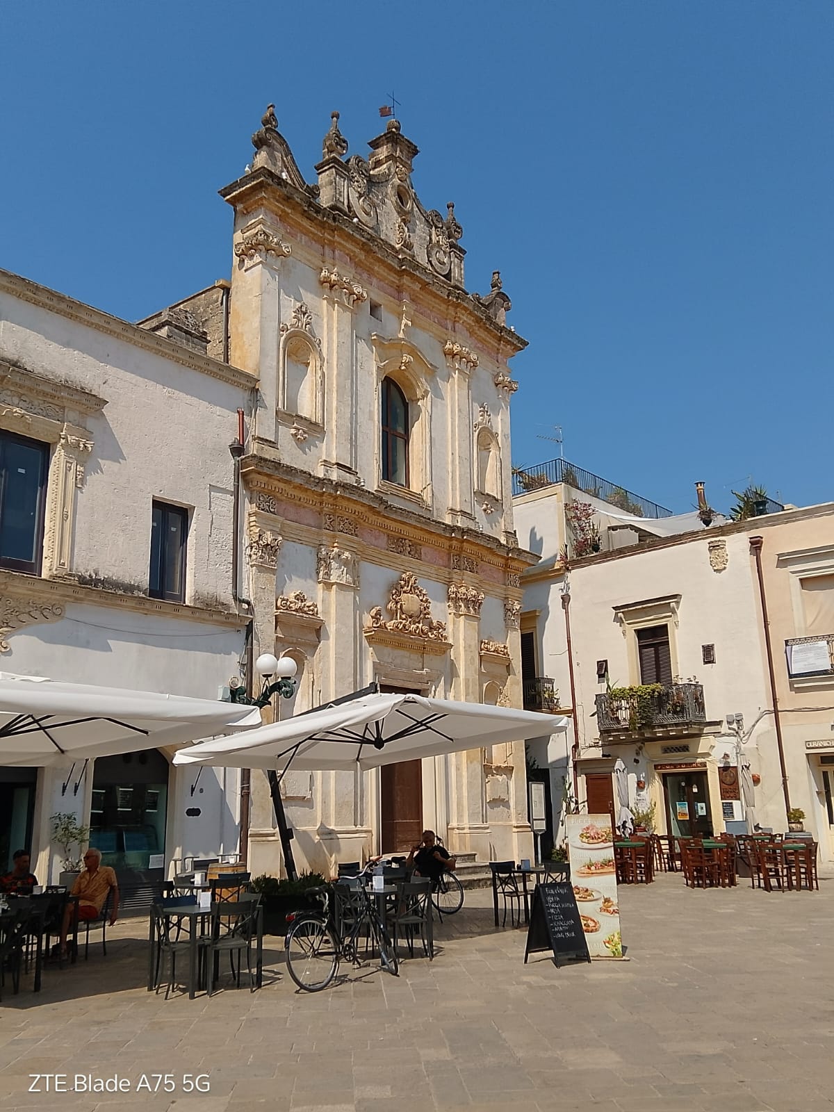 Igreja e cafés na praça de Nardò.