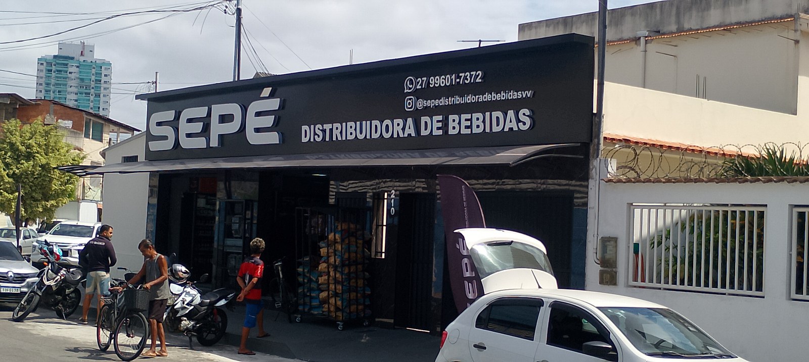 Frente da loja com placa principal e acesso para compra no local.